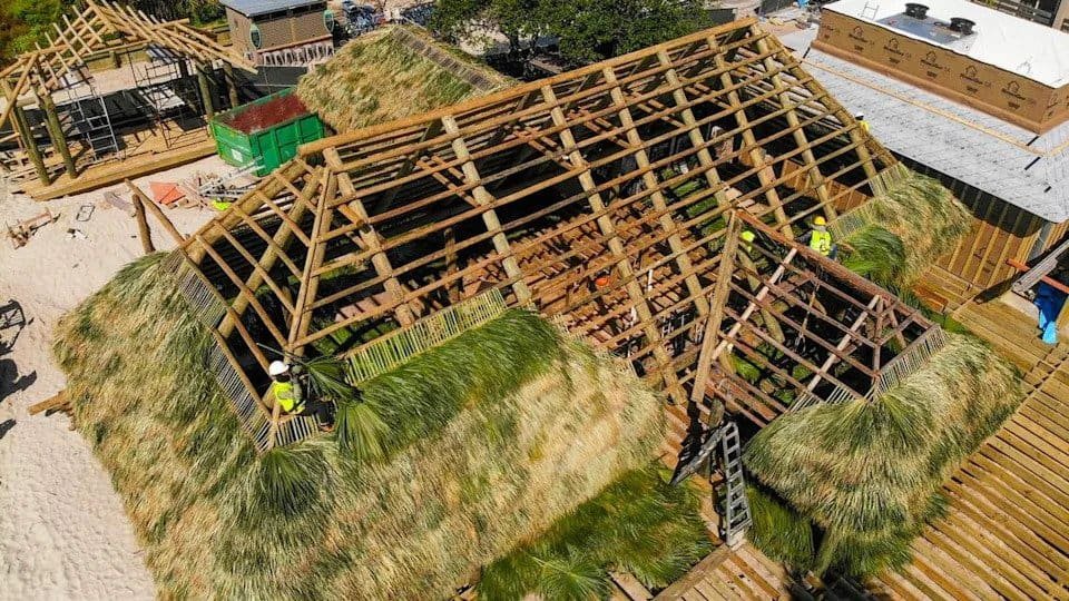 Tiki hut frame being built with bamboo and thatch roofing materials in Florida.