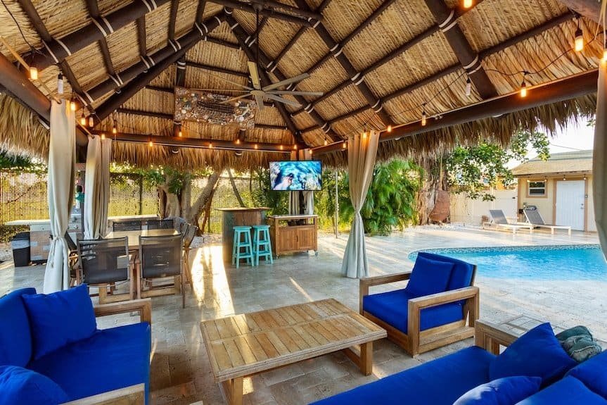 Outdoor Tiki Hut with Comfortable Seating and TV.