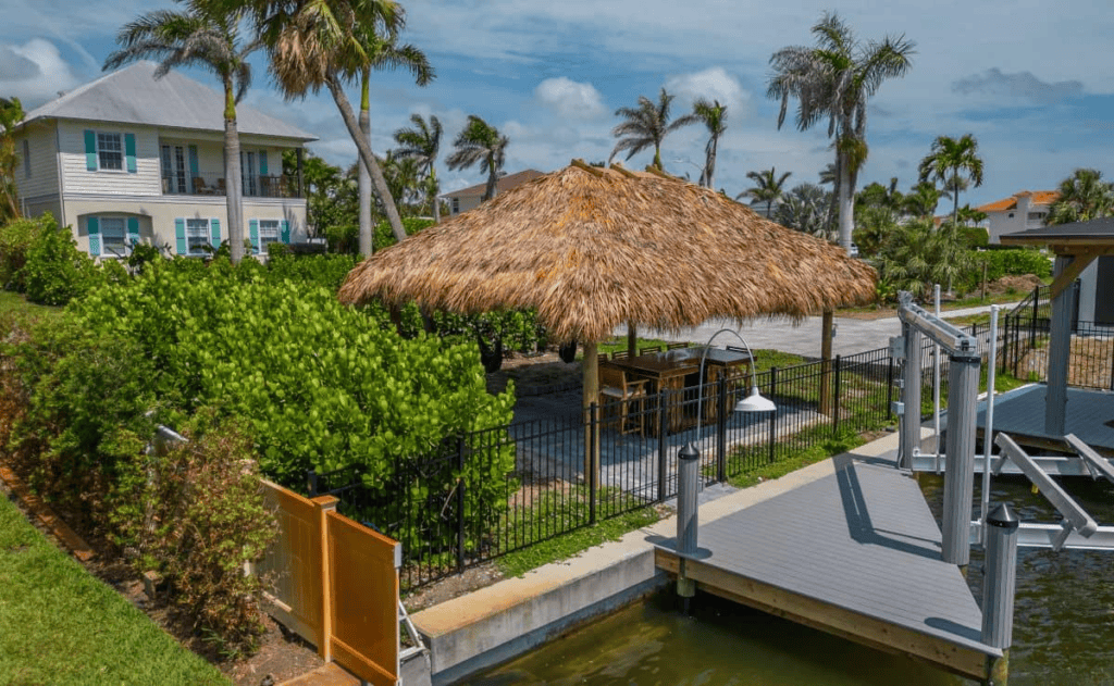 Traditional tiki hut with thatched roof in a tropical Florida setting.